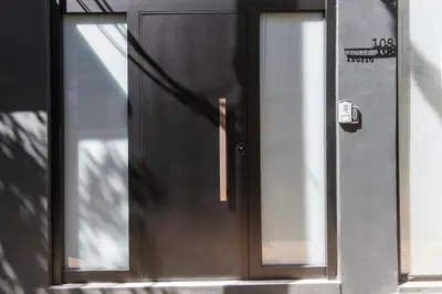 a black door with two windows on a building at Isoyio in Piraeus