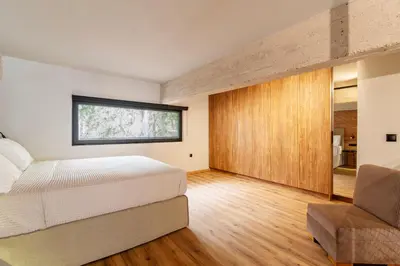 a bedroom with a bed and a window and a chair at Isoyio in Piraeus