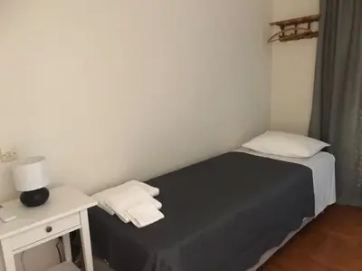 a small bedroom with a bed and a white table at Quiet penthouse at 5th floor in Athens