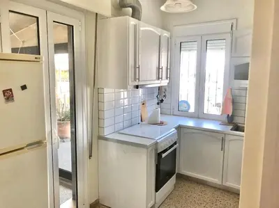 a kitchen with white cabinets and white appliances at Quiet penthouse at 5th floor in Athens