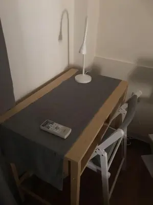 a table with a lamp and a remote control on it at Quiet penthouse at 5th floor in Athens