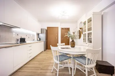 a kitchen with white cabinets and a table and chairs at Athens Homster in Athens