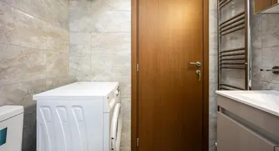 a bathroom with a washer and dryer next to a sink at Athens Homster in Athens