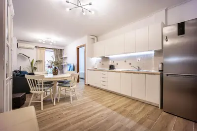 a kitchen with white cabinets and a table with chairs at Athens Homster in Athens