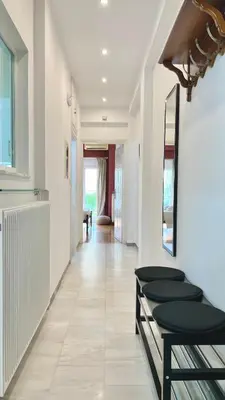 a hallway with white walls and a mirror at Elegant apartment in Thissio in Athens