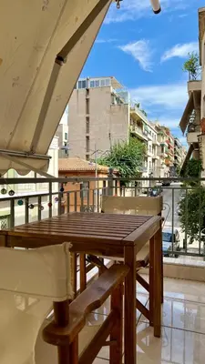 a wooden table and chairs on a balcony at Elegant apartment in Thissio in Athens