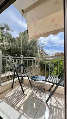 a patio with a chair and a table on a balcony at Elegant apartment in Thissio in Athens