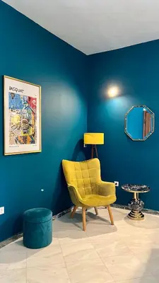 a yellow chair in a room with a blue wall at Elegant apartment in Thissio in Athens