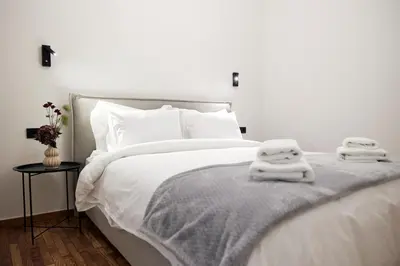 a white bed with two towels on top of it at Cozy Apartment in Larisis 9-11 in Athens