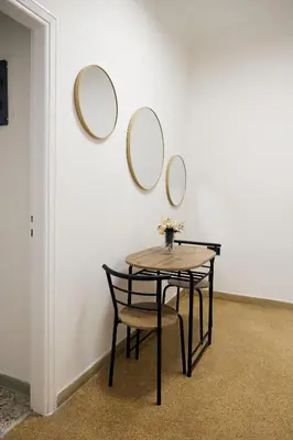 a table and a chair with three mirrors on a wall at Cozy Apartment in Larisis 9-11 in Athens
