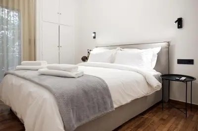 a bedroom with a large bed with white sheets and pillows at Cozy Apartment in Larisis 9-11 in Athens