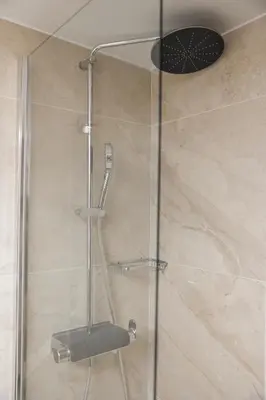 a shower with a glass door with a stool at Cozy Apartment in Larisis 9-11 in Athens
