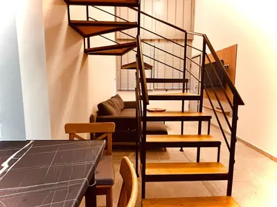 a spiral staircase in a living room with a table at Loft Athens 2 - 55m2 in Athens