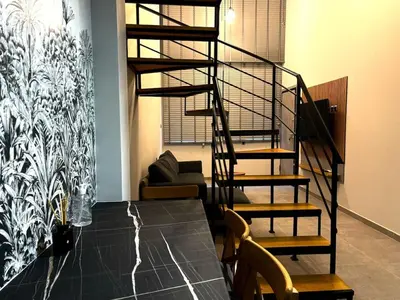 a spiral staircase in a living room with a couch at Loft Athens 2 - 55m2 in Athens