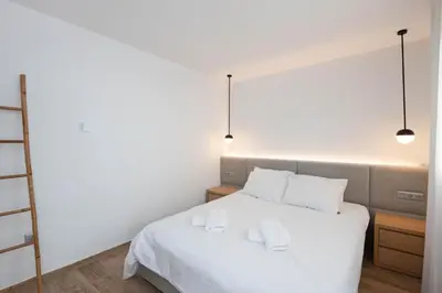 a bedroom with a white bed with two white towels at Zeus3 Beach Front Appartment, 2 BR, Sea View in Athens