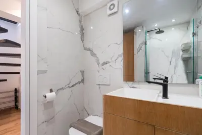 a bathroom with a sink and a marble wall at Zeus3 Beach Front Appartment, 2 BR, Sea View in Athens