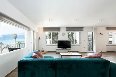 a living room with a blue couch and a large window at Zeus3 Beach Front Appartment, 2 BR, Sea View in Athens
