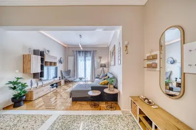 a living room with a couch and a mirror at Manolias Apartment in Athens