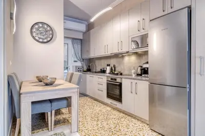 a kitchen with a table and a refrigerator at Manolias Apartment in Athens