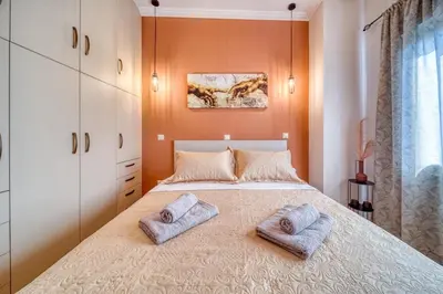 a bedroom with a bed with two towels on it at Manolias Apartment in Athens