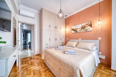 a bedroom with a large bed with orange walls at Manolias Apartment in Athens