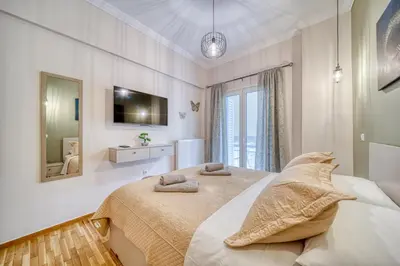 a bedroom with a large bed and a mirror at Manolias Apartment in Athens