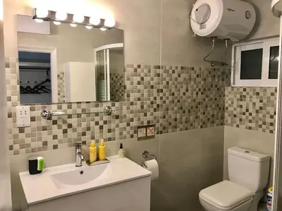 a bathroom with a sink and a toilet and a mirror at Modern Studio - Terrace & Seaview - Close to Beach in Saronida