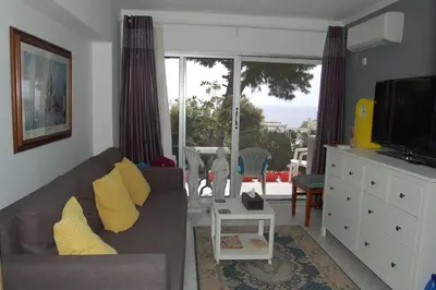 a living room with a couch and a tv at Modern Studio - Terrace & Seaview - Close to Beach in Saronida