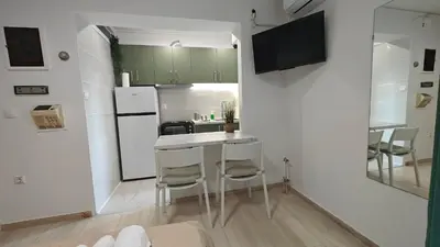 a kitchen with green cabinets and a white refrigerator at Inspire Apartment Palaio Faliro in Athens