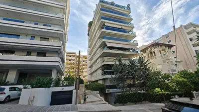 a tall building with cars parked in front of it at Inspire Apartment Palaio Faliro in Athens