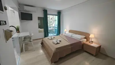 a bedroom with a bed and a desk and a window at Inspire Apartment Palaio Faliro in Athens