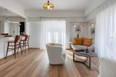 a living room with white chairs and a table at Kolonaki Suite with Panoramic View in Athens