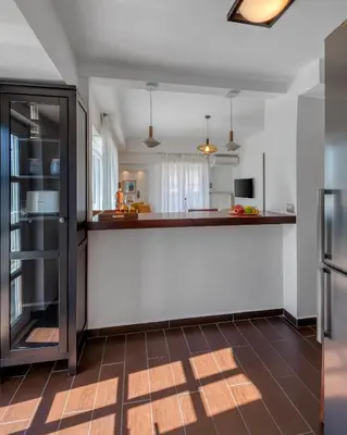 a kitchen with white walls and a brown floor at Kolonaki Suite with Panoramic View in Athens