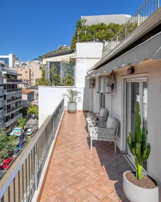 a balcony with a couch and chairs on a building at Kolonaki Suite with Panoramic View in Athens