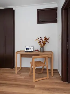 a wooden table with a chair in a room at Kolonaki Suite with Panoramic View in Athens