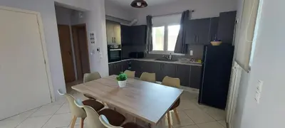 a kitchen with a wooden table and chairs at Gianni & Sophia airport house in Artemida
