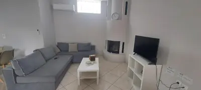a living room with a couch and a tv at Gianni & Sophia airport house in Artemida