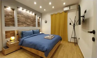 a bedroom with a bed with a blue comforter at Rock Garden in Athens