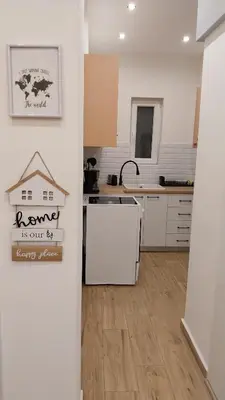 a kitchen with white cabinets and a counter top at Rock Garden in Athens