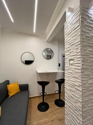 a living room with a couch and two stools at Rock Garden in Athens