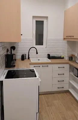 a kitchen with white cabinets and a sink at Rock Garden in Athens