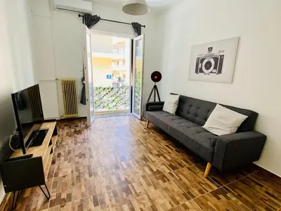 a living room with a couch and a television at Koukaki comfortable apartment in Athens