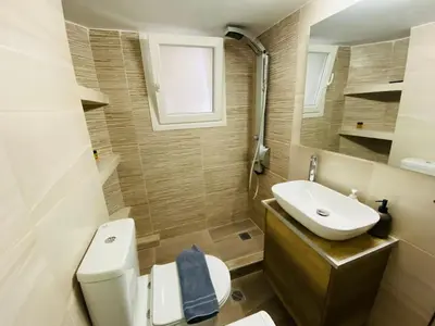 a bathroom with a white toilet and a sink at Koukaki comfortable apartment in Athens