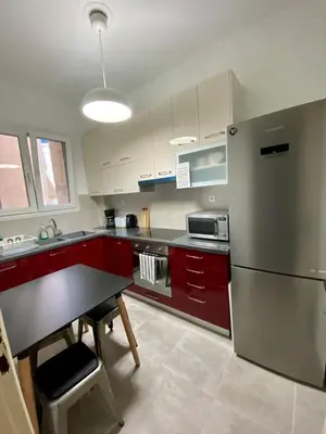 a kitchen with red cabinets and a stainless steel refrigerator at Koukaki comfortable apartment in Athens