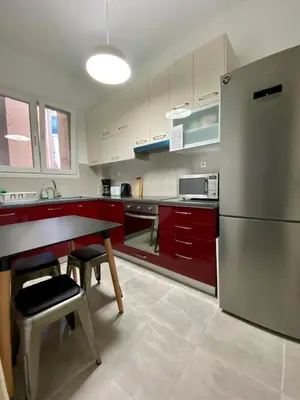 a kitchen with red cabinets and a stainless steel refrigerator at Koukaki comfortable apartment in Athens