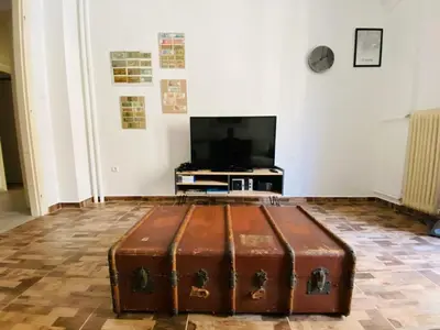 an old trunk sitting in a room with a tv at Koukaki comfortable apartment in Athens