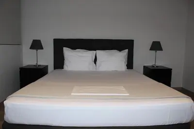 a bed with white sheets and pillows in a bedroom at Apartment At Historic Center of Athens in Athens