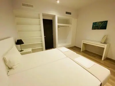 a white bedroom with a bed and a desk at Apartment At Historic Center of Athens in Athens