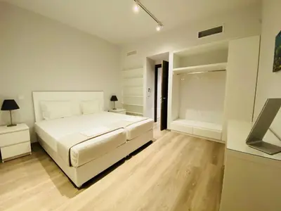 a white bedroom with a bed and a bath tub at Apartment At Historic Center of Athens in Athens