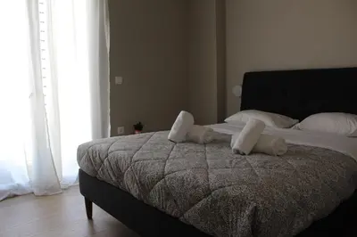 a bedroom with a bed with white sheets and pillows at Keramikos Stylish living in Athens